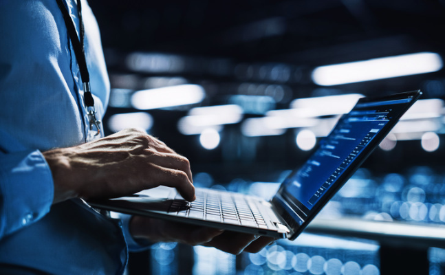 Trader holding a laptop to watch educational video tutorials on forward contracts